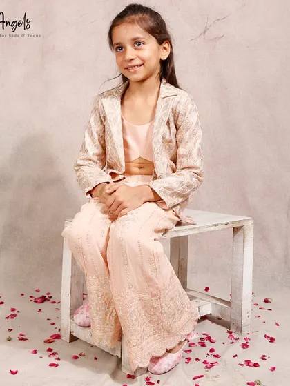 This three piece set with a crop top, palazzo pants, and an embroidered jacket is a chic indo western option.