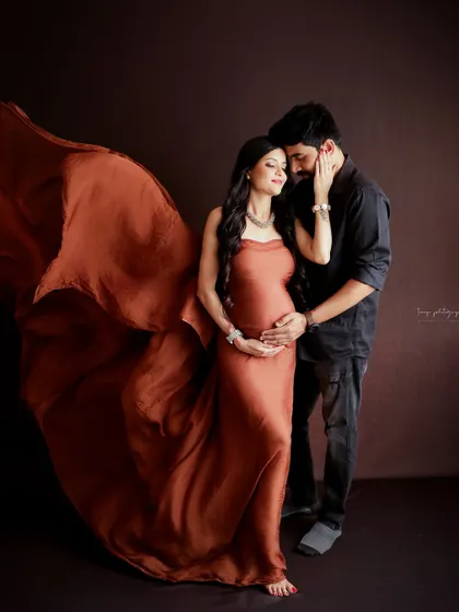 A dramatic and elegant couple's portrait. The flowing fabric of the gown and their intimate pose create a stunning and artistic image.