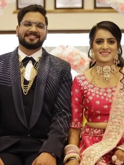 A beautiful couple at their reception. The bride is wearing a custom pastel pink choker set that I designed to match her stunning pink lehenga.
