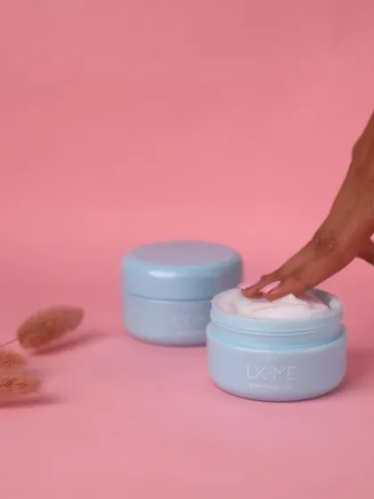 Adding a human element to the shot. A finger dipping into the cream makes the product more relatable and tempting, showing off its rich texture.