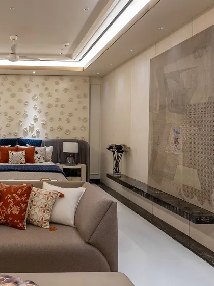 In this bedroom, a large piece of art is the focal point, complemented by a custom-designed bed with a unique, textured headboard. The space feels both artistic and serene.