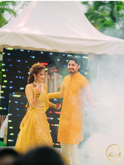 The couple makes a grand entrance with a smoke machine, adding a touch of drama to their Haldi event.