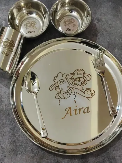 A complete stainless steel dinner set for kids, engraved with their name and a fun cartoon character like Shaun the Sheep.