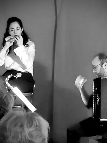 A black and white shot of our soprano playing the harmonica, accompanied by the accordion. This shows the versatility within the performance, as we incorporate different sounds to tell the story of Italian folk music.
