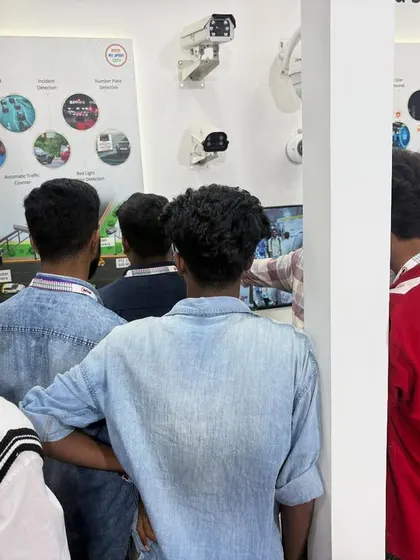 A group of young enthusiasts gathered around a product demonstration at AutoSec 2025. Inspiring the next generation of engineers and security professionals is part of my mission.