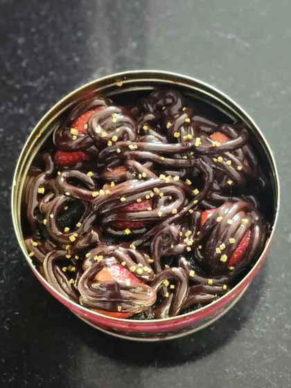 The finished chocolate and strawberry creation, all packed in a convenient tin. The combination of rich chocolate, fresh fruit, and crunchy sprinkles makes for a dessert with wonderful textures and flavors.