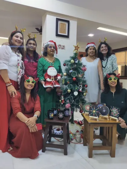 The entire group from the Christmas art party posing with their creations, capturing the festive spirit and shared accomplishment.