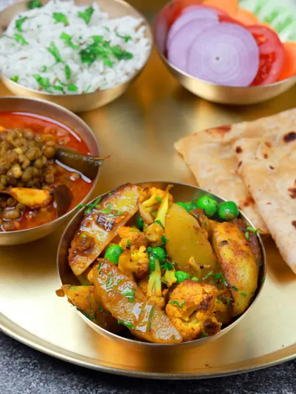 A comforting plate of aloo gobi matar, whole masoor dal, rice, and roti. This is the kind of meal that feels like a warm hug.