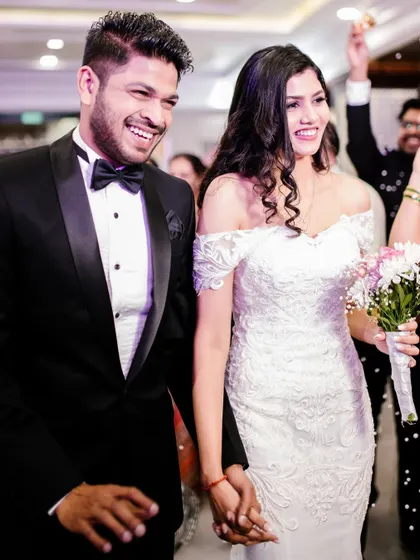 A joyous exit. The bride's radiant smile and flawless makeup capture the happiness of the moment.