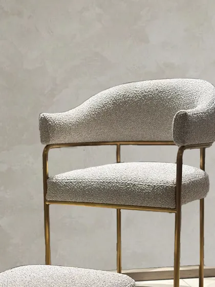 A closer look at the junction between the upholstered armrest and the metal frame. This detail highlights the precise craftsmanship required to merge different materials into a single, cohesive form.