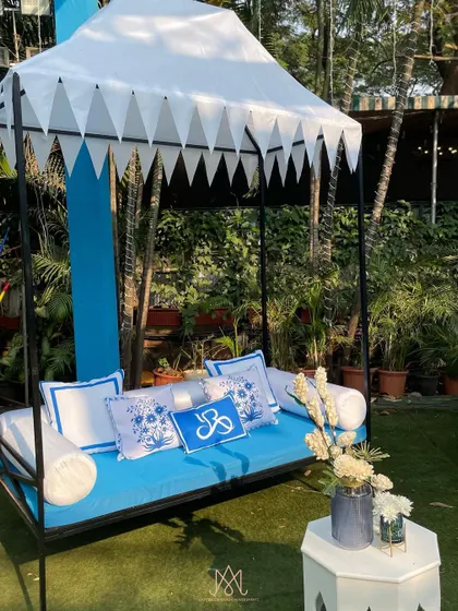 A close-up of a canopied daybed, showing the personalized cushions and intricate details that make the decor special.