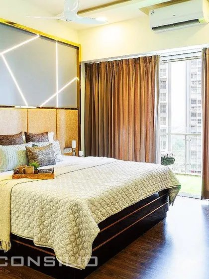 A stunning feature wall in a master bedroom. We created a geometric pattern with profile lighting on a grey panel, set above a cushioned golden headboard. It's a perfect blend of modern art and comfort.