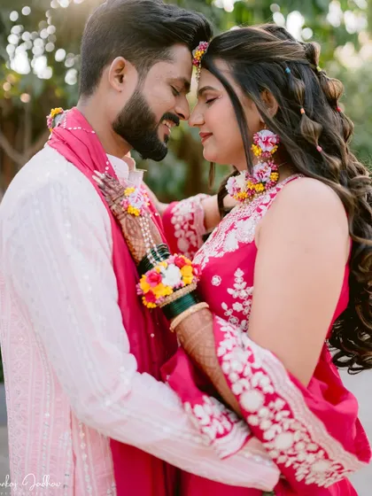 An intimate portrait from a Haldi ceremony, focusing on the couple's connection and the beautiful floral jewelry.
