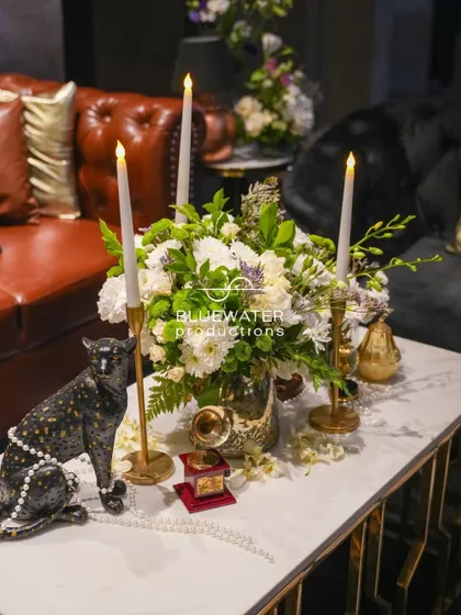 Another angle of the vintage-inspired centerpiece, combining a bold panther statue with delicate pearls, candles, and a fresh floral arrangement.