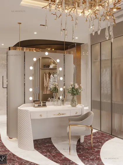 The vanity in this dressing room is a statement piece, with a classic Hollywood-style mirror, elegant white cabinetry, and a custom chandelier that drips with crystals.