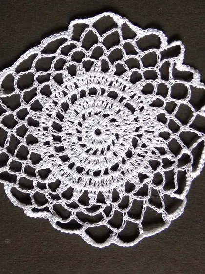 An 8-inch white crochet doily.