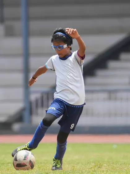 A player strikes the ball with perfect technique on a natural grass pitch in Ooty.