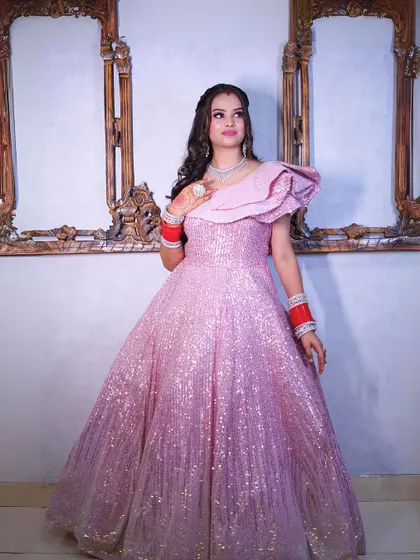 A full-length view of our sparkling pink sequin gown with a dramatic one-shoulder ruffle.