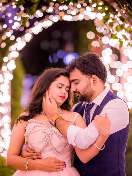 A tender moment between a couple, surrounded by the soft blur of countless fairy lights. This is a classic example of a romantic pre-wedding photo that feels both intimate and grand.