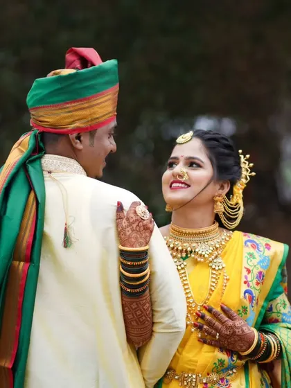 A romantic pose of the couple in their traditional yellow and green wedding outfits, sharing a loving glance.
