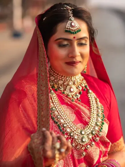 The bride looking regal with her sword. The deep red lip and defined eyes add to the royal elegance of her look.