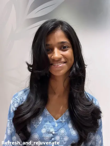 The client smiling, clearly happy with her fresh, minimal, and classy new haircut.