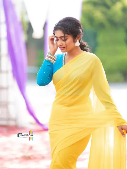 A candid-style shot showing the flow of the yellow saree and the fit of the custom blue blouse. It's a simple look made special with the right color combination.