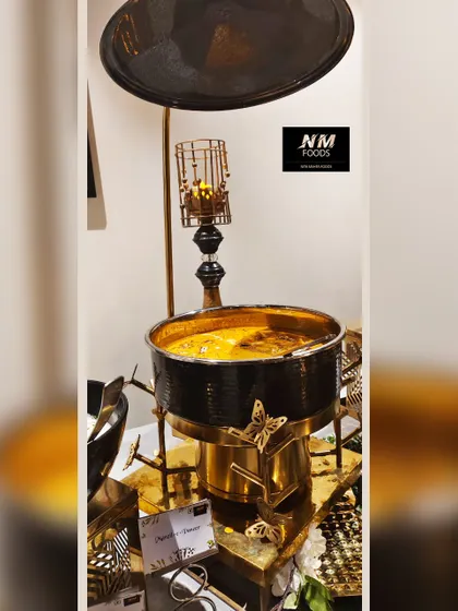 A close-up of one of our ornate chafing dishes. The combination of the black pot with gold butterfly accents creates a look of modern luxury that elevates any buffet line.
