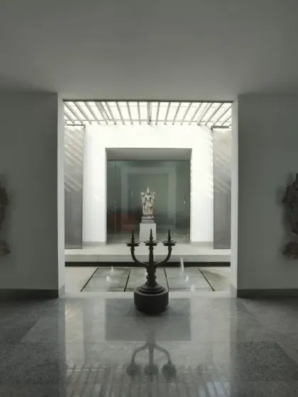 A symmetrical and serene courtyard space at an office in Coimbatore. The design uses water, sculpture, and reflected light to create a formal yet tranquil entry sequence, establishing a sense of balance and order.