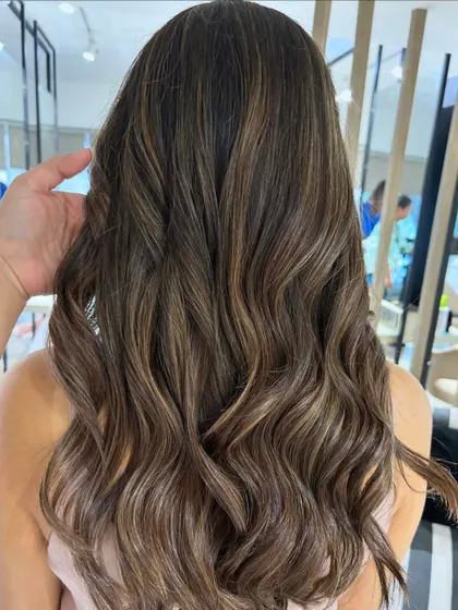 A cool beige blonde highlight blend created with a balayage technique. This is a great way to achieve a lighter look while maintaining a natural, blended root.