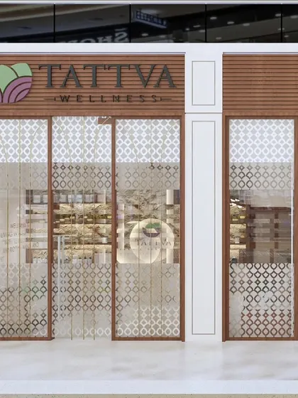 The storefront design for Tattva Wellness, a spa where serenity begins at the entrance. We used wood and intricate jali patterns on the glass to create a sense of calm and privacy.