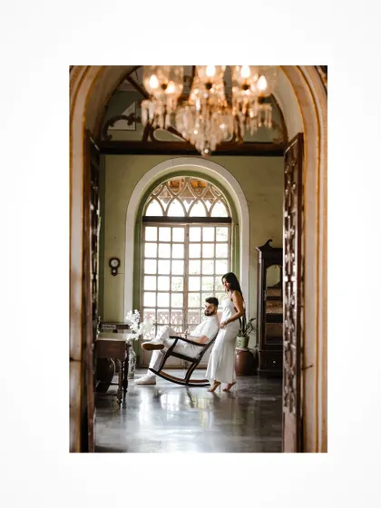 An elegant portrait captured through a doorway, adding depth and context to the pre-wedding shoot.