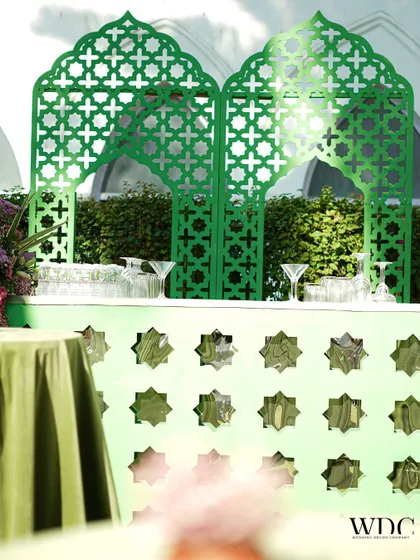 A closer look at the intricate jali work on the bar, showcasing the star-shaped cutouts and the beautiful sage green color that defined this elegant theme.