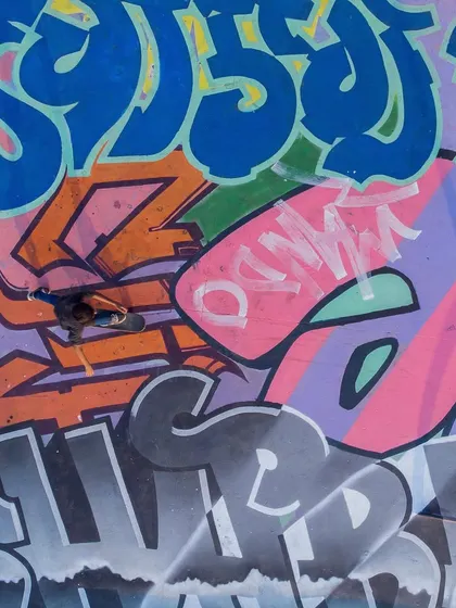 An overhead shot capturing a skater flowing over the complex layers of graffiti from different artists at the Mumbai Urban Art Festival.
