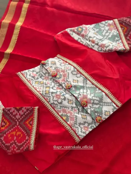 A red blouse with a printed ikat-style panel.