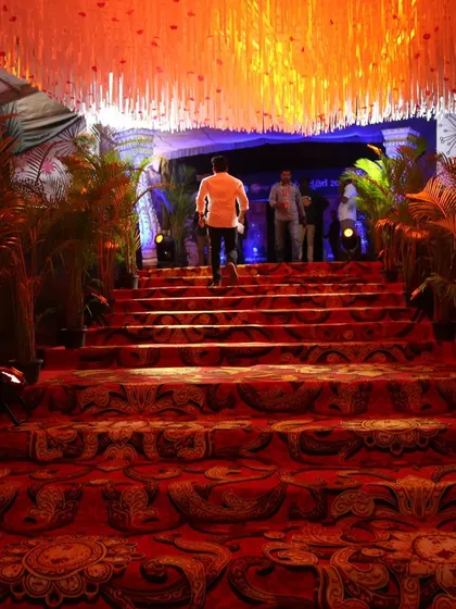 A guest makes a grand entrance up the decorated staircase at the Zee Kannada event, showcasing the immersive experience we create from the moment of arrival.