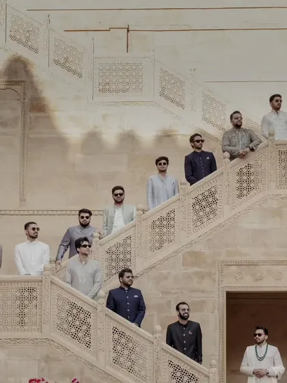 The groom's squad, looking dapper and ready for the celebration. This stylish group portrait on the intricately carved staircases of Suryagarh captures the cool, regal vibe of the wedding party.