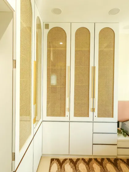 Another angle of the white and rattan wardrobe, showing how it fits perfectly into the corner to maximize space.