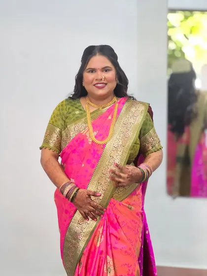 A full view of the client's look. The simple hairstyle balances the vibrant colors and rich texture of her traditional saree.