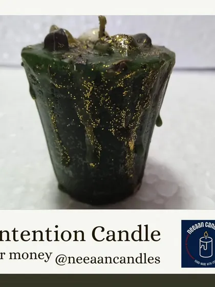 This is my intention candle for money, topped with crystals and sprinkled with gold dust. It's designed to help you focus on your monetary goals and manifest prosperity.