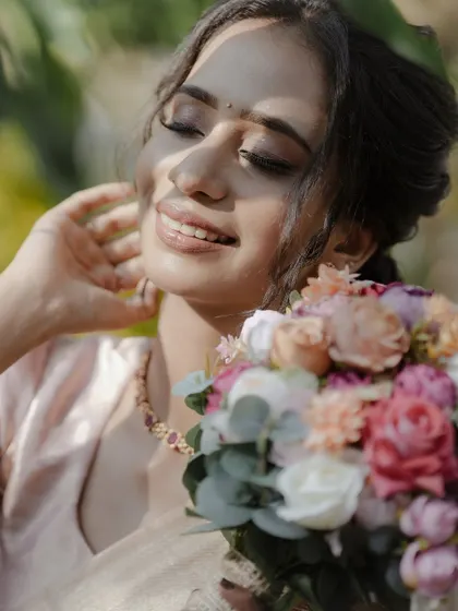 The bride, bathed in sunlight, holds her bouquet and smiles, a picture of pure happiness and grace.