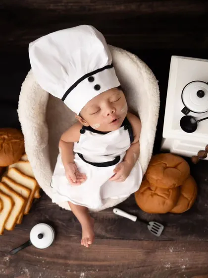 A full view of the chef-themed newborn setup, with bread props and a miniature kitchen counter creating a delightful scene.