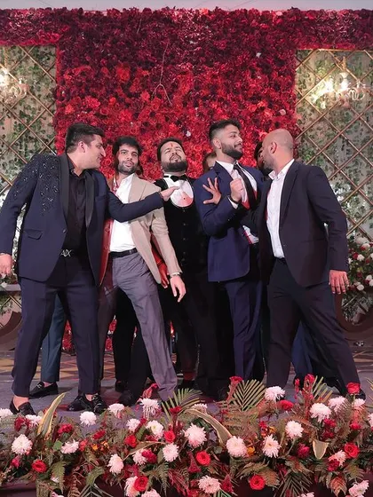 A fun, candid moment from the groomsmen's performance. It's all about celebrating the groom and having a great time together on stage.