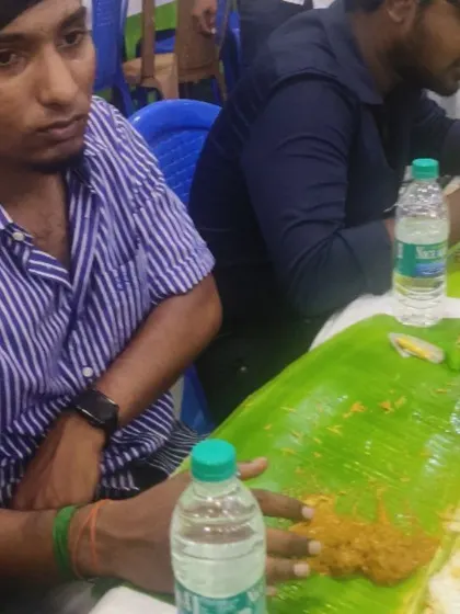 Guests focused on enjoying the delicious biryani and side dishes served on a fresh banana leaf.