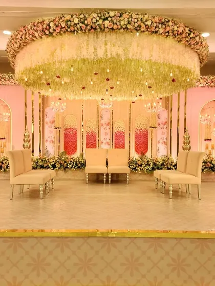 Here is a full view of an elegant pastel stage I designed for an engagement. The setup features a massive floral chandelier, soft pink backdrops with intricate arches, and plush seating, creating a sophisticated and romantic focal point.