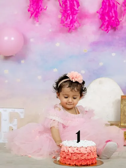 A slightly different angle from the pastel-themed first birthday shoot, showing the beautiful setup with balloons, flowers, and vintage-style suitcases.