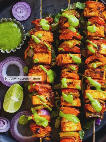 Our Paneer Tikka skewers feature soft paneer cubes marinated in spices and grilled with bell peppers and onions. This popular North Indian appetizer is a vibrant and flavorful start to any celebration.