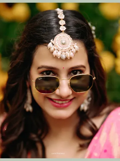 The bride looking cool and chic in sunglasses at her Haldi, a fun and modern bridal portrait.