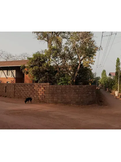 A wide shot of Maison Rouge from the street, capturing its context within the local village.