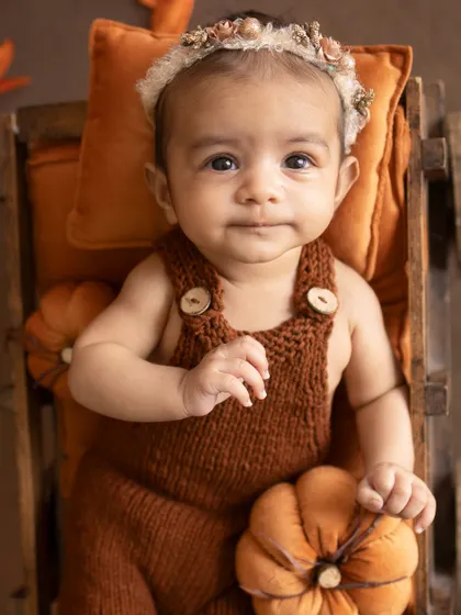 A thoughtful look. This baby is calmly observing her surroundings from her cozy little wagon.